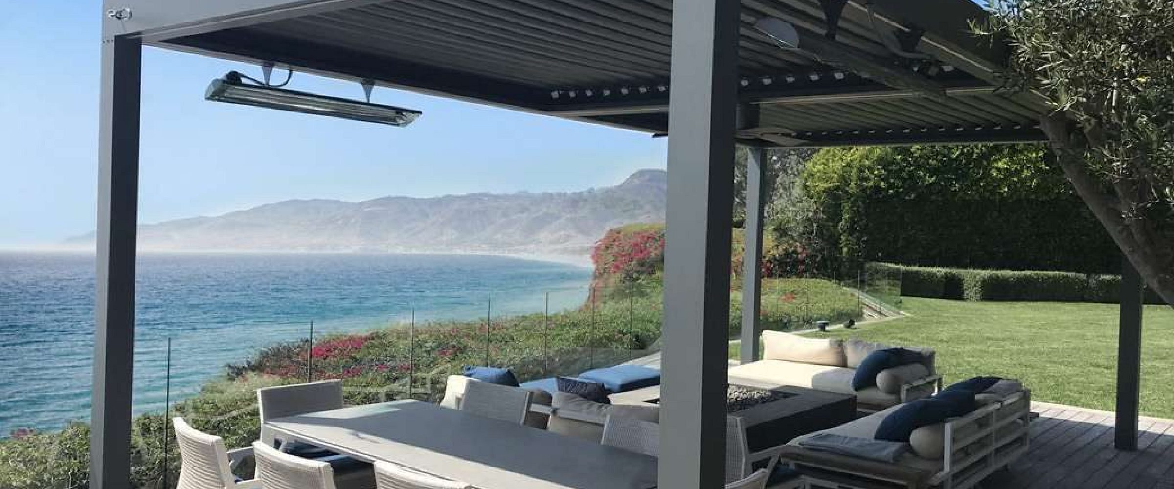 An aluminium pergola with a scenic coastal backdrop